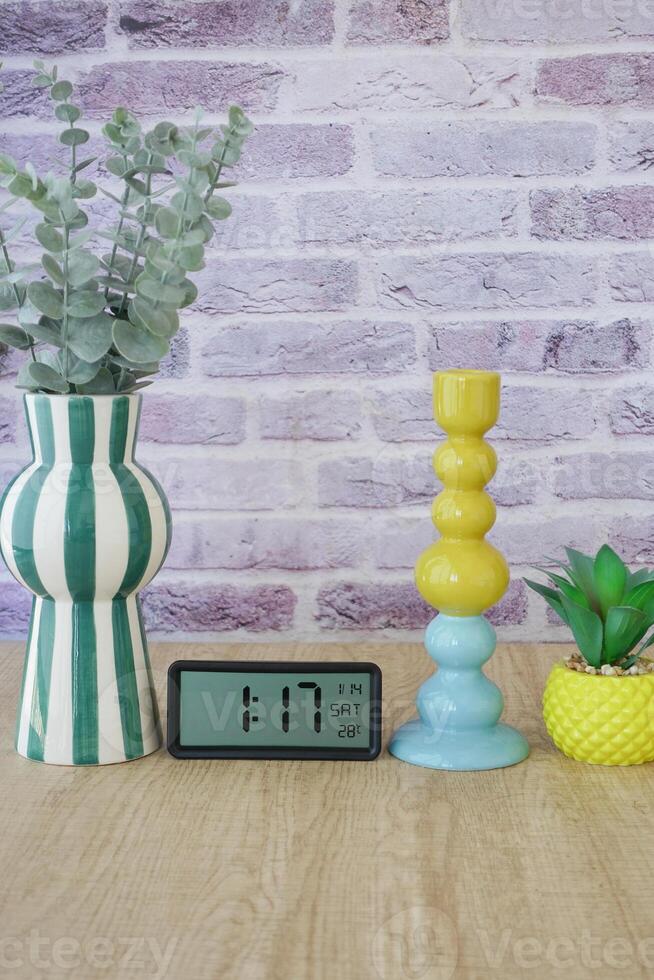 A Vibrant Decorative Arrangement Featuring a Modern Clock Surrounded by Lush Plants photo