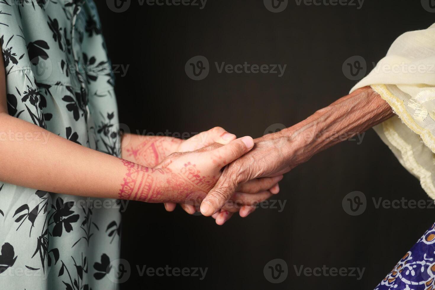 close up of child hand holding senior women's hand photo