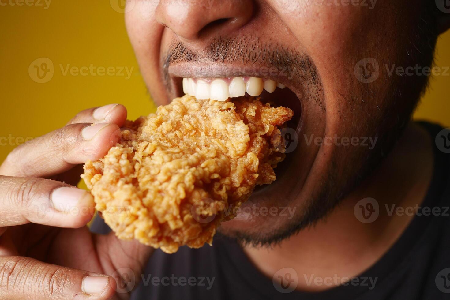 A Delicious Plate of Fried Chicken Happily Enjoyed by a Smiling Person at a Restaurant photo