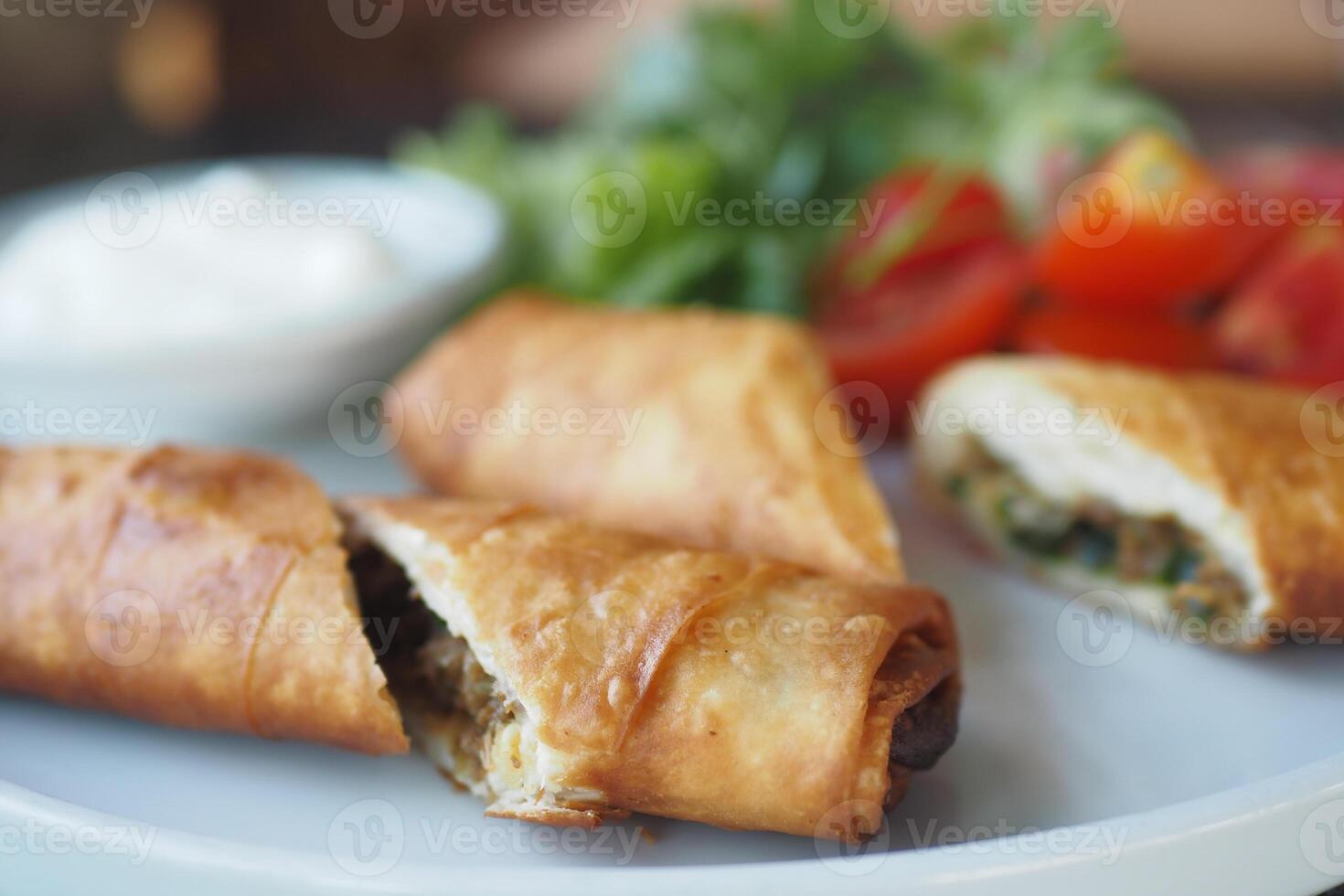 Enjoy Crispy Spring Rolls stuffed with Fresh Vegetables and served with a tasty Dipping Sauce photo