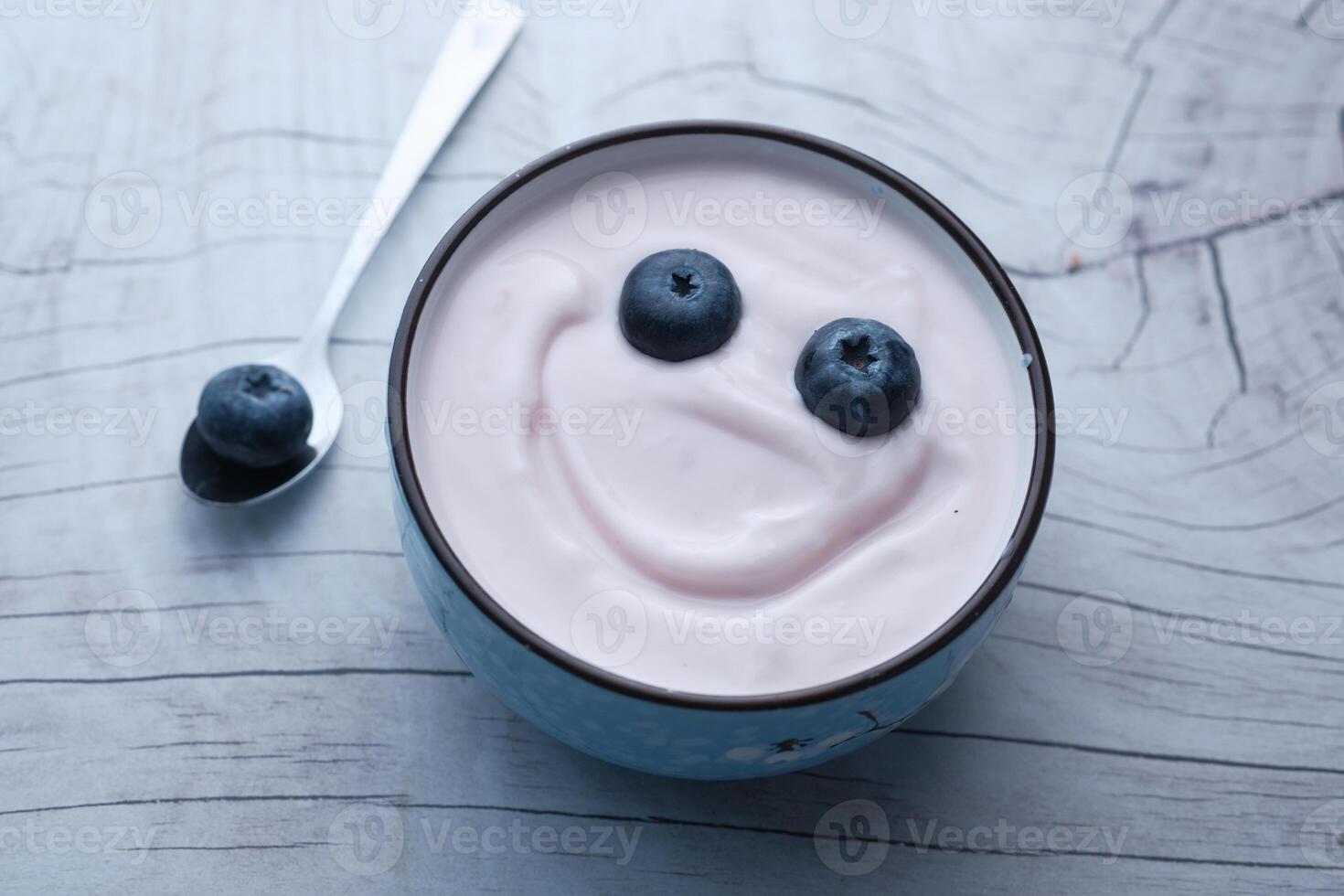 A Delightfully Delicious Yogurt Bowl Topped with Fresh Blueberries and a Cheerful Smiley Face photo
