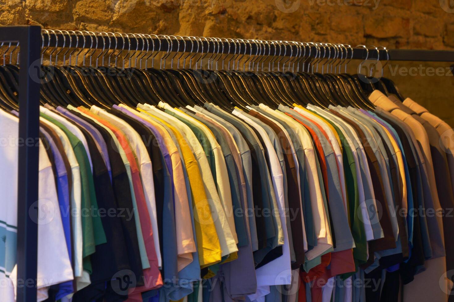 A stylish boutique showcases an array of vibrant hanging Tshirts in a wellorganized display photo