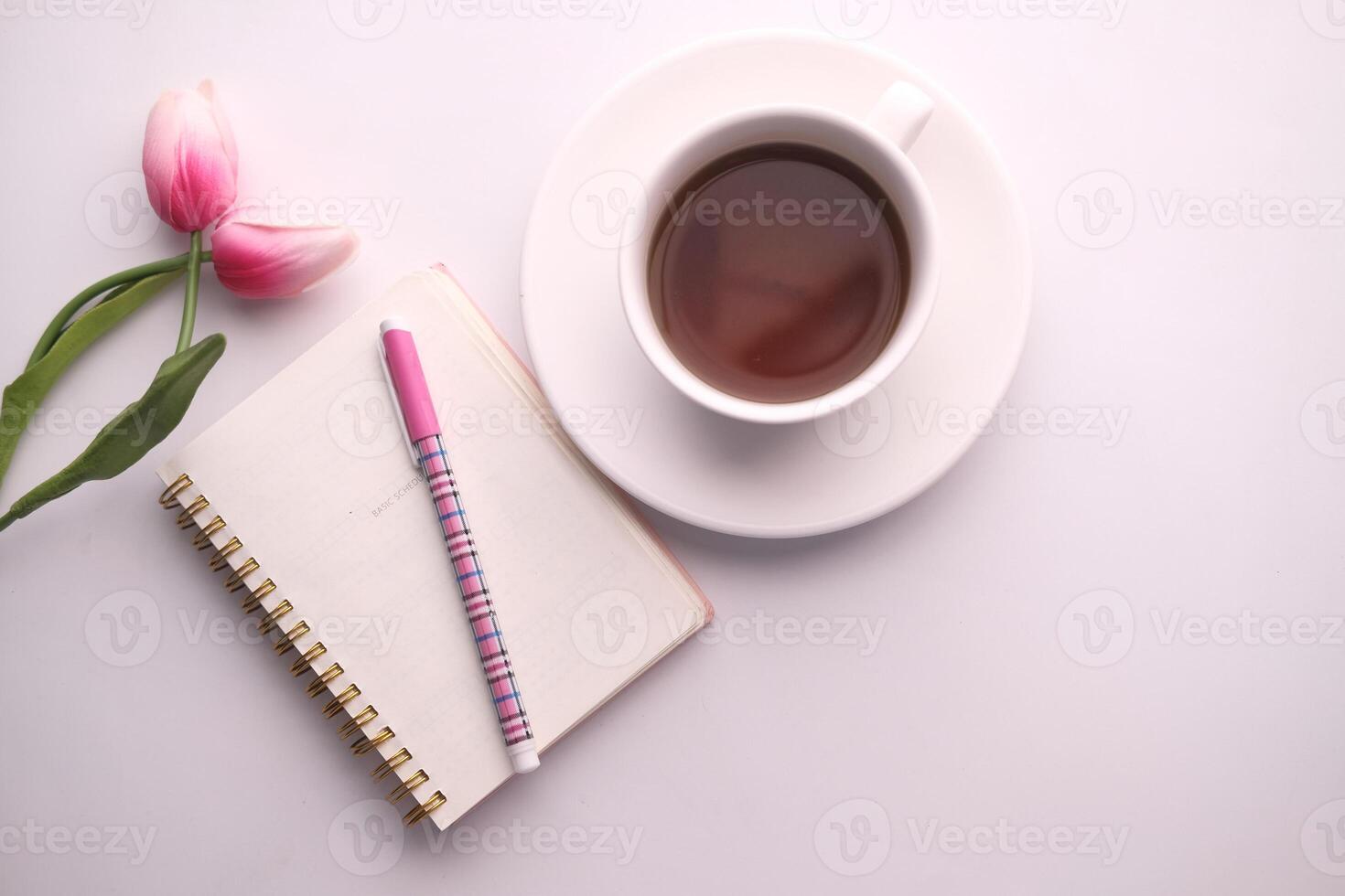 A Cozy Workspace Featuring Coffee, a Notepad, and Beautiful Tulips for Daily Inspiration photo