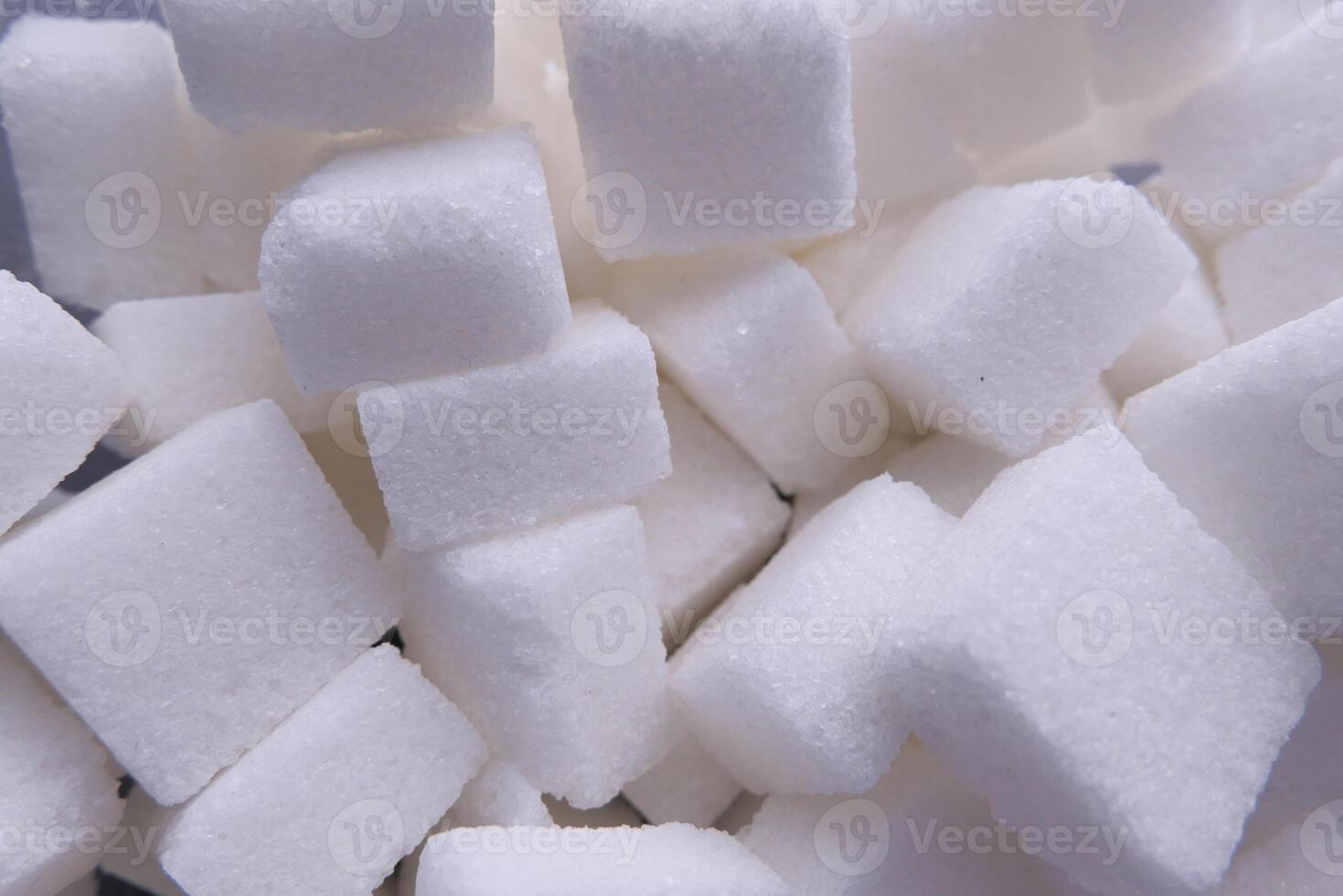 A closeup view of several white sugar cubes arranged on a gray background surface photo