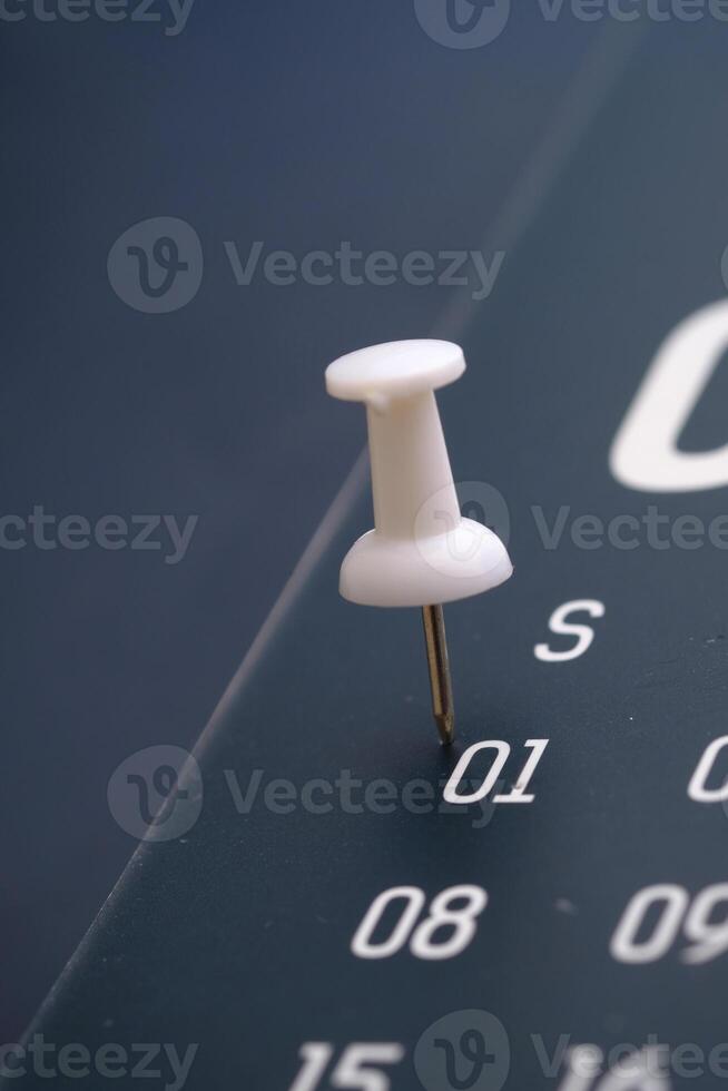 A CloseUp Image of a Pushpin Placed on a Calendar Date Highlighting January 1st photo