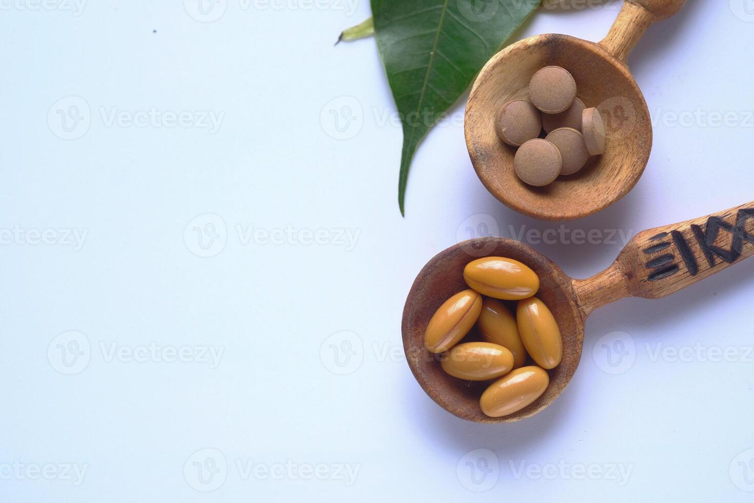 Natural Dietary Supplements Presented in Charming Wooden Spoons with an Accompanying Leaf photo