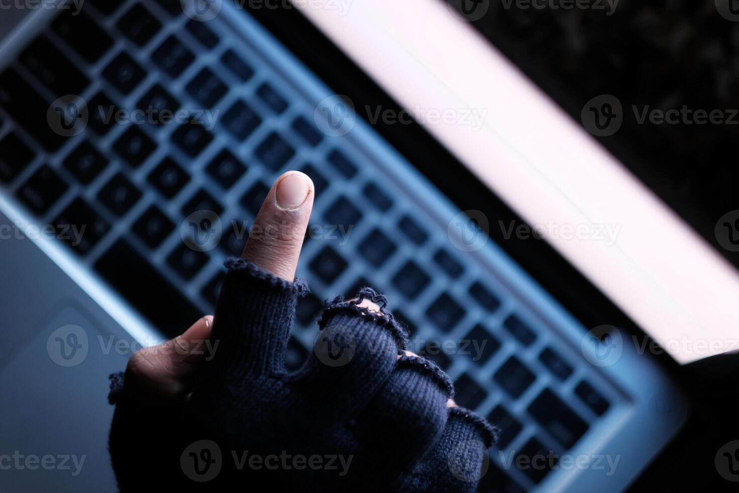 hacker hand stealing data from laptop top down photo