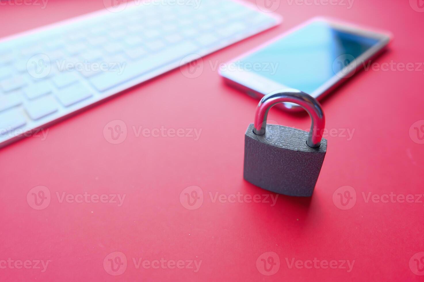 Cyber Security is shown by a padlock on a smartphone with a red background, symbolizing safety photo