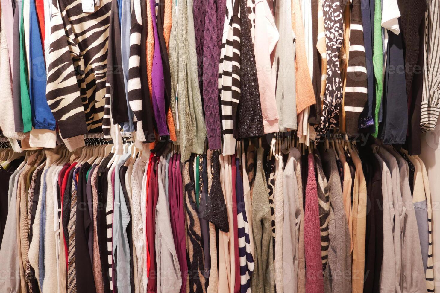 A Colorful Wardrobe that is Full of Various Clothing Items Neatly Organized on Hangers photo