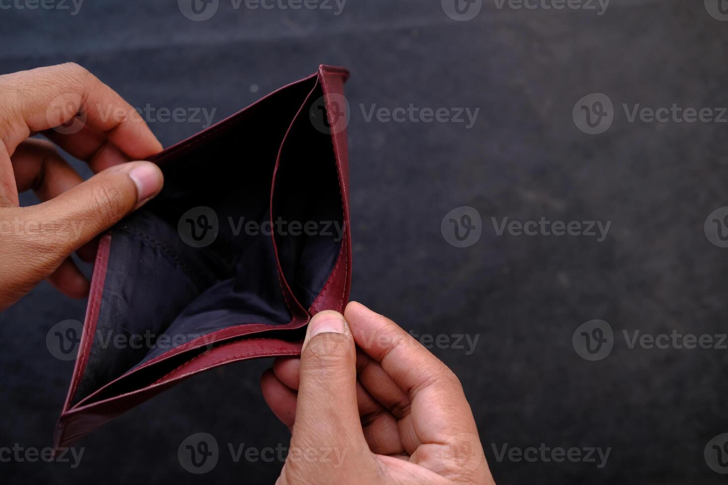 An empty wallet held in hands symbolizes the challenges and difficulties of financial struggles photo