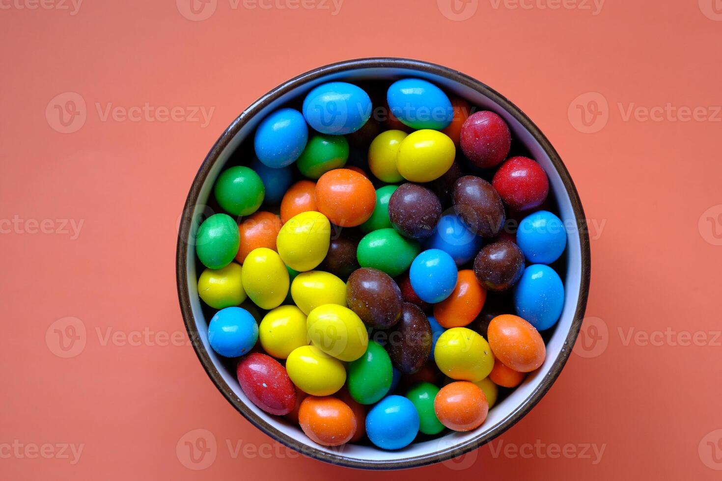 A Vibrant and Colorful Candy Bowl Filled with an Assortment of Delicious Chocolate Treats photo