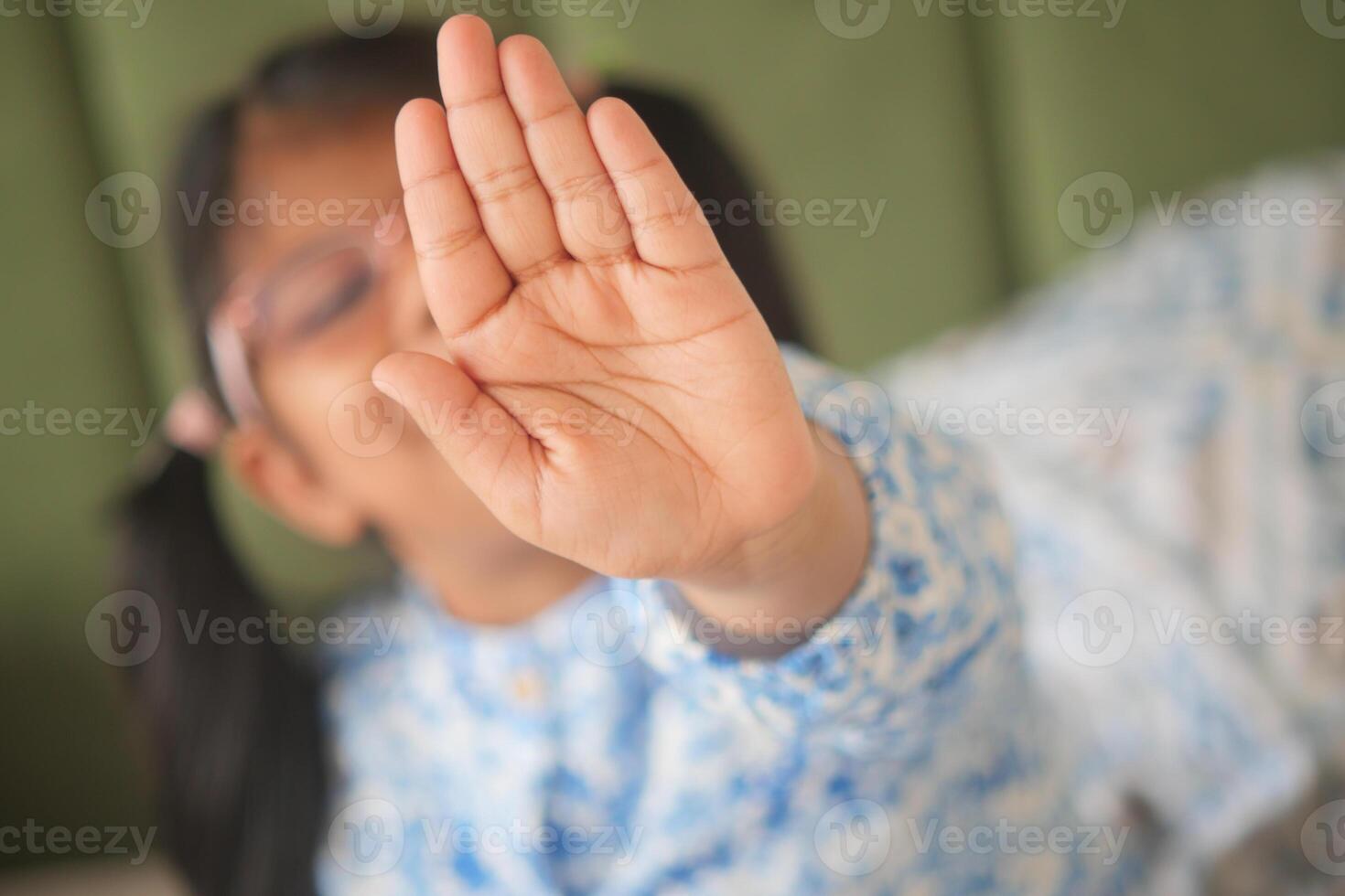 A Young Child Playfully and Joyfully Reaching Out with a Big Stop Gesture for Fun Activities photo