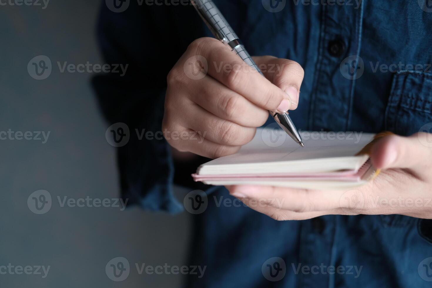A person writes in a notebook with a pen in a casual setting that inspires creativity photo
