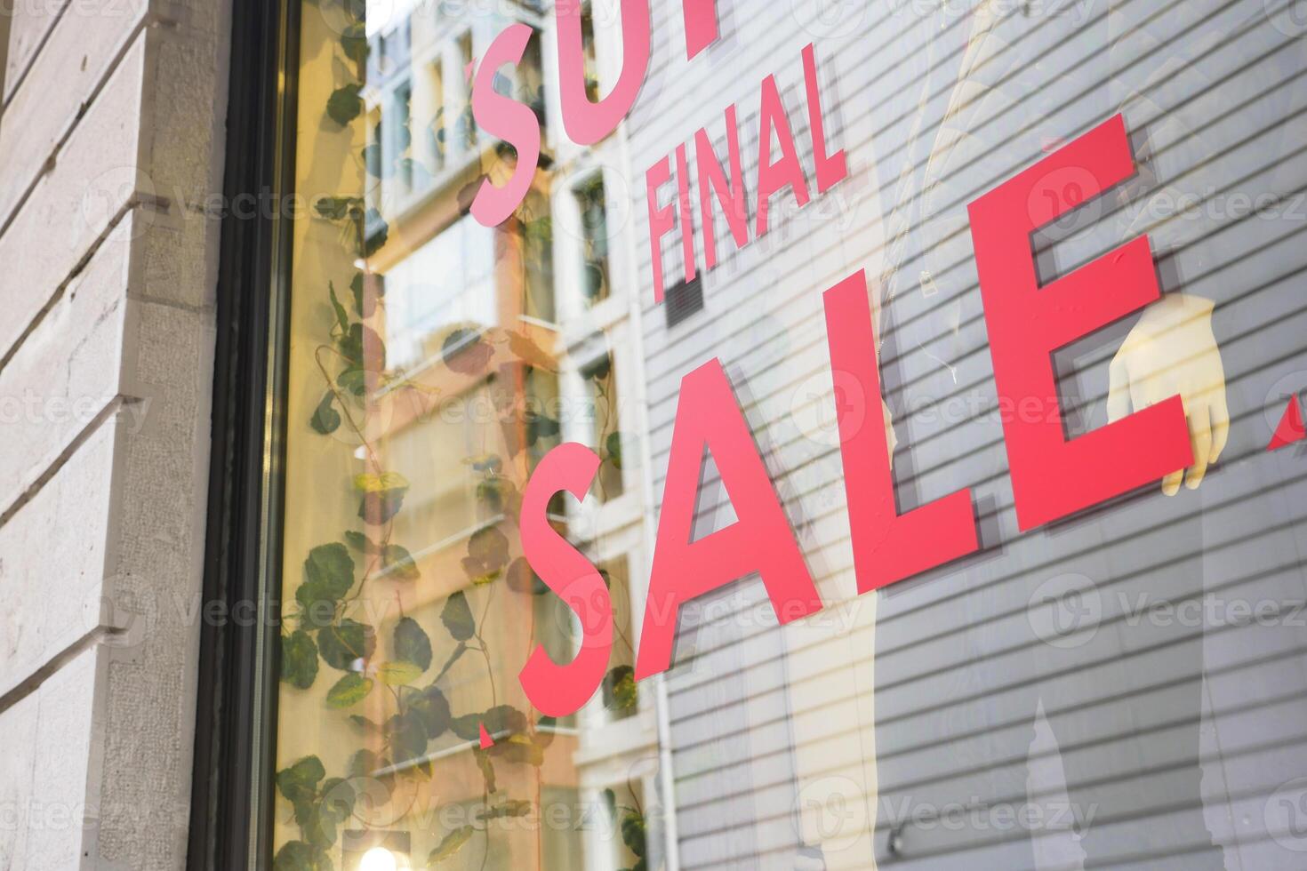 Large red Sale text letters on a glass wall obstruct a view inside the popular fashion store photo