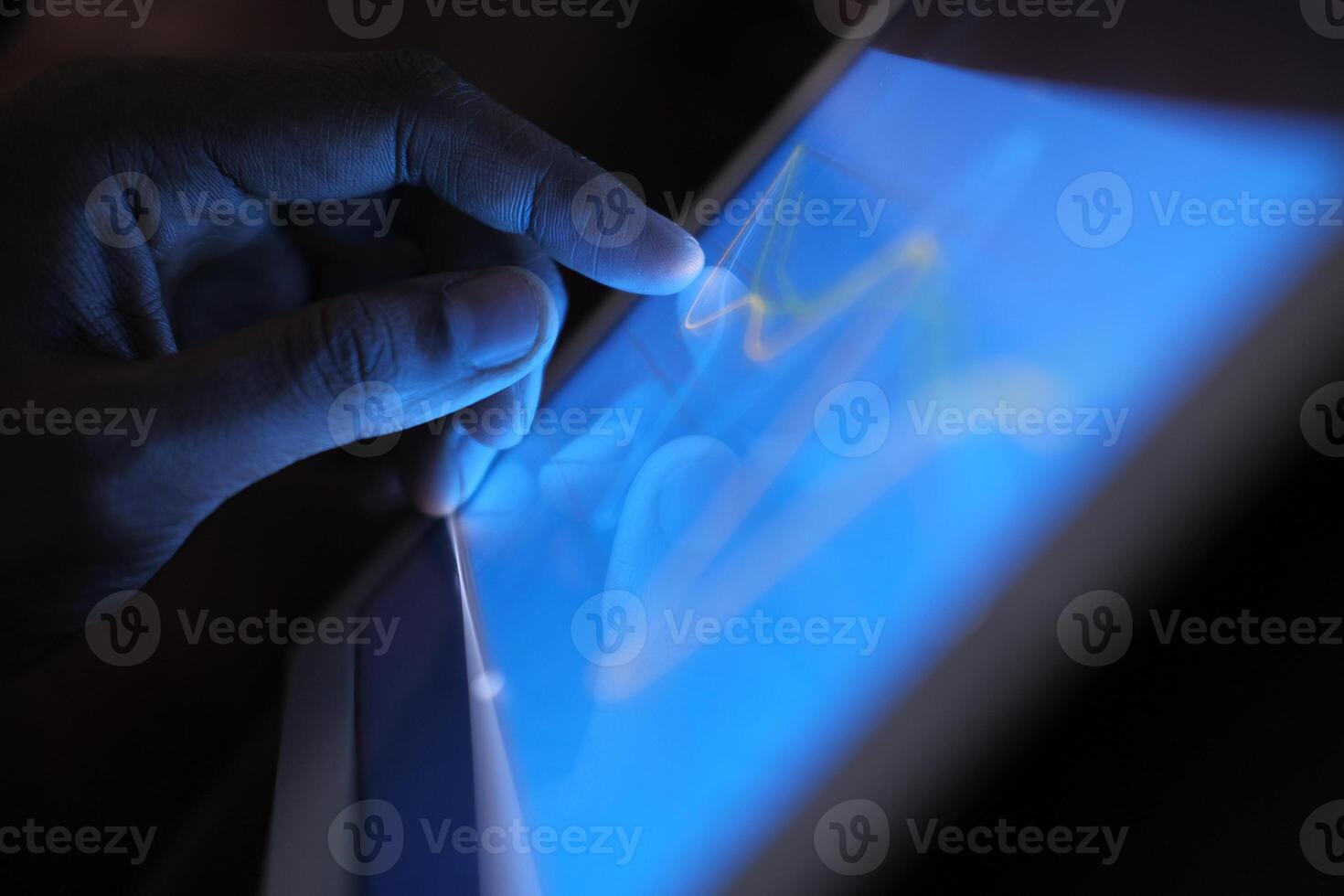A detailed and closeup view of a hand engaging with a modern touchscreen electronic device photo