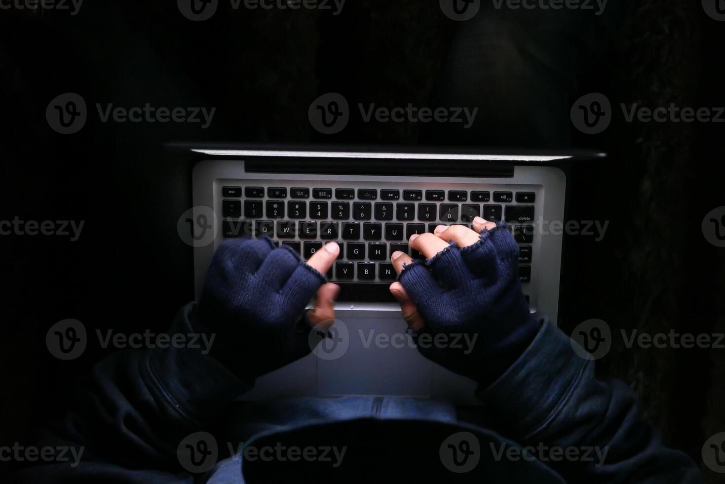 hacker hand stealing data from laptop top down photo