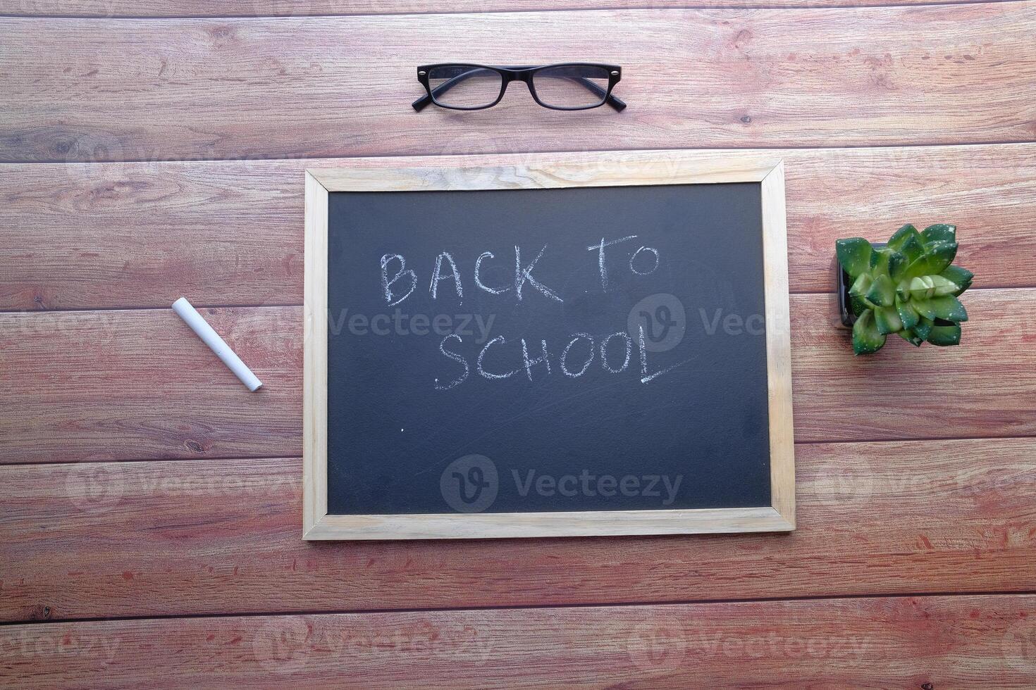 Essential Items for Going Back to School A Chalkboard, Stylish Glasses, and Greenery photo