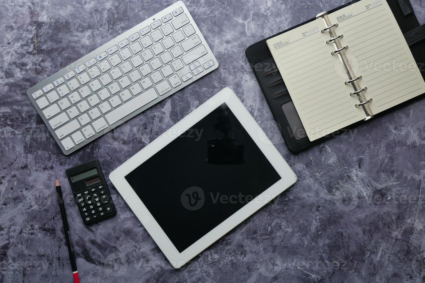 A Contemporary Modern Workspace Featuring a Tablet, Keyboard, and Organized Planner photo