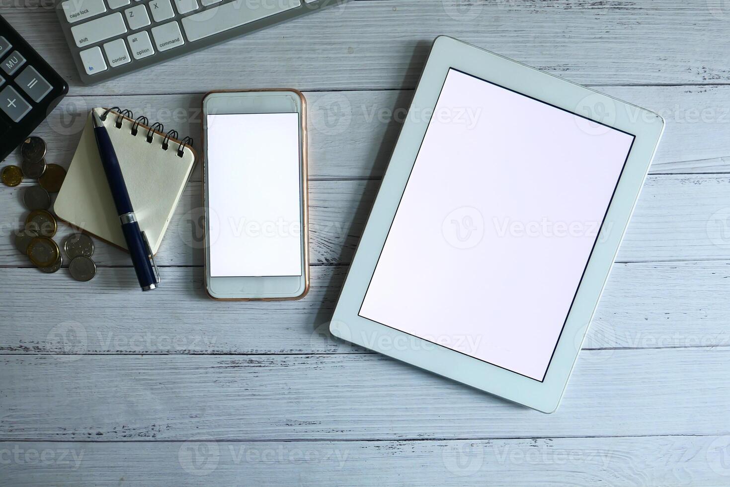 A Modern Workspace Featuring a Tablet and Smartphone Positioned on a Stylish Wooden Desk photo