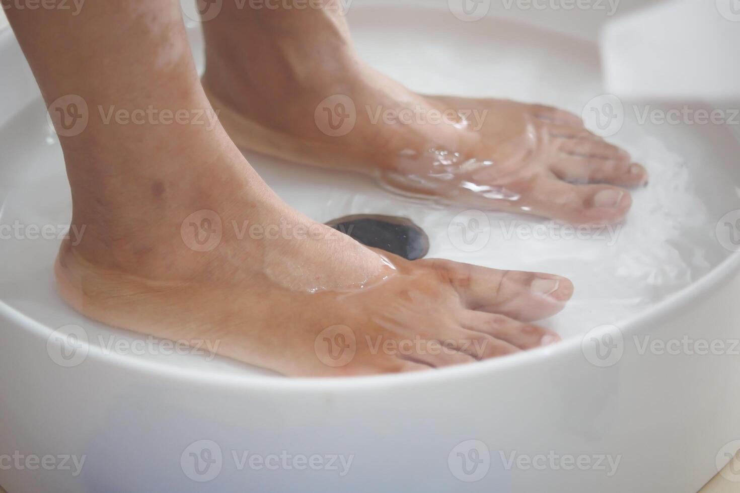 Indulge in a Relaxing Foot Bath with Smooth Pebbles Perfect for an Ultimate Spa Treatment Experience photo