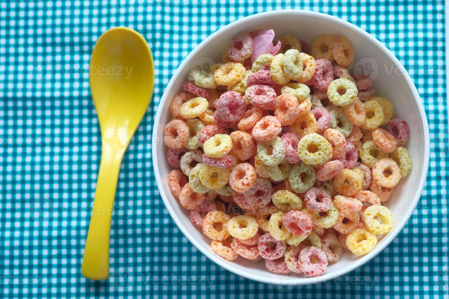 A colorful breakfast cereal in a bowl with a yellow spoon, ready for a cheerful meal photo