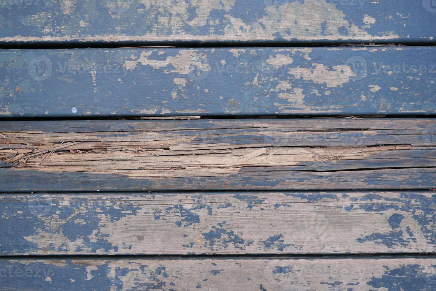 Weathered blue wooden planks with peeling paint and damage create an interesting texture photo