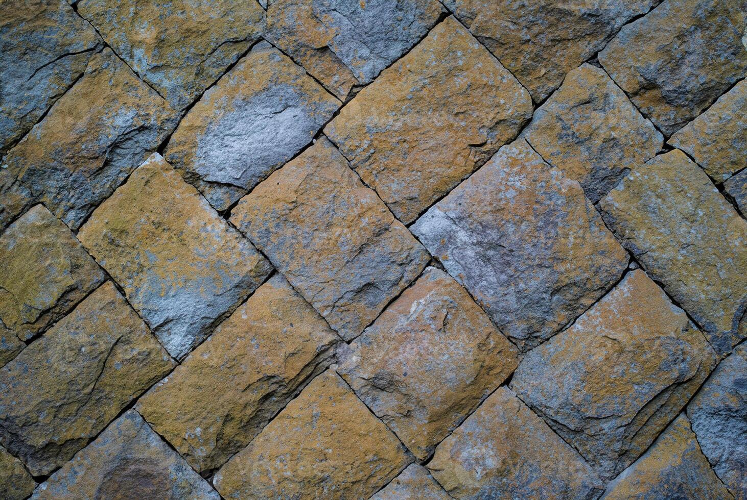 Close-up of a rustic stone wall with natural texture, ideal for backgrounds, architectural, or design elements. photo