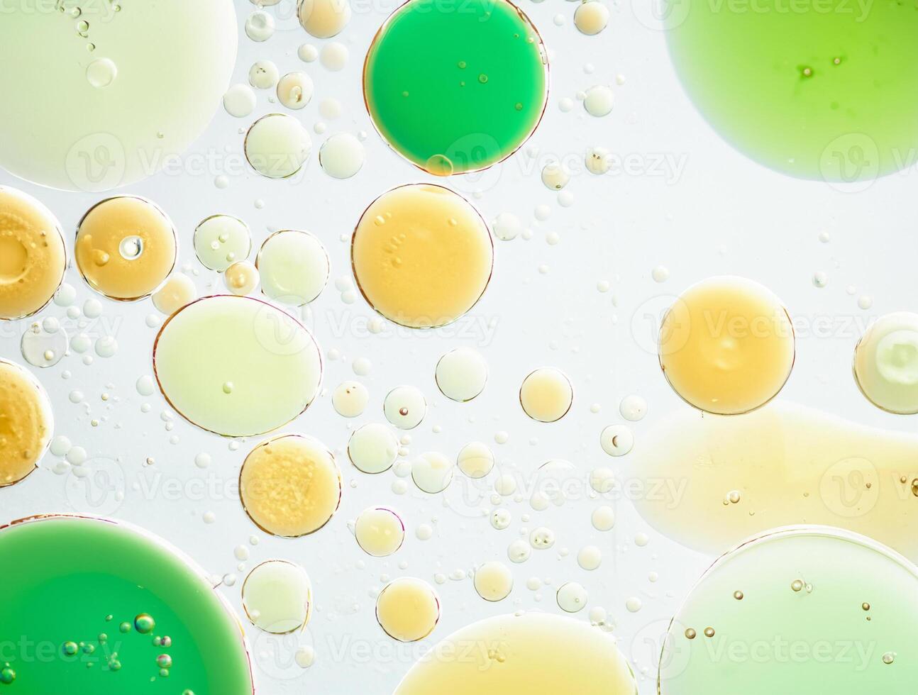Close-up of oil and water bubbles in various sizes floating on a pale background, abstract texture. photo