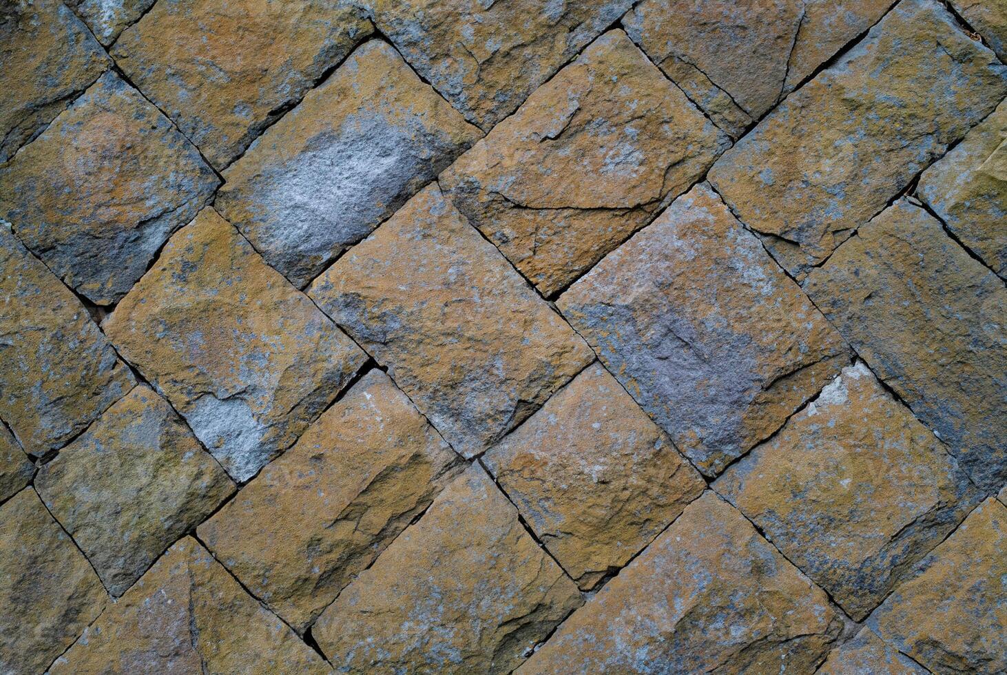 Close-up of a rustic stone wall with natural texture, ideal for backgrounds, architectural, or design elements. photo