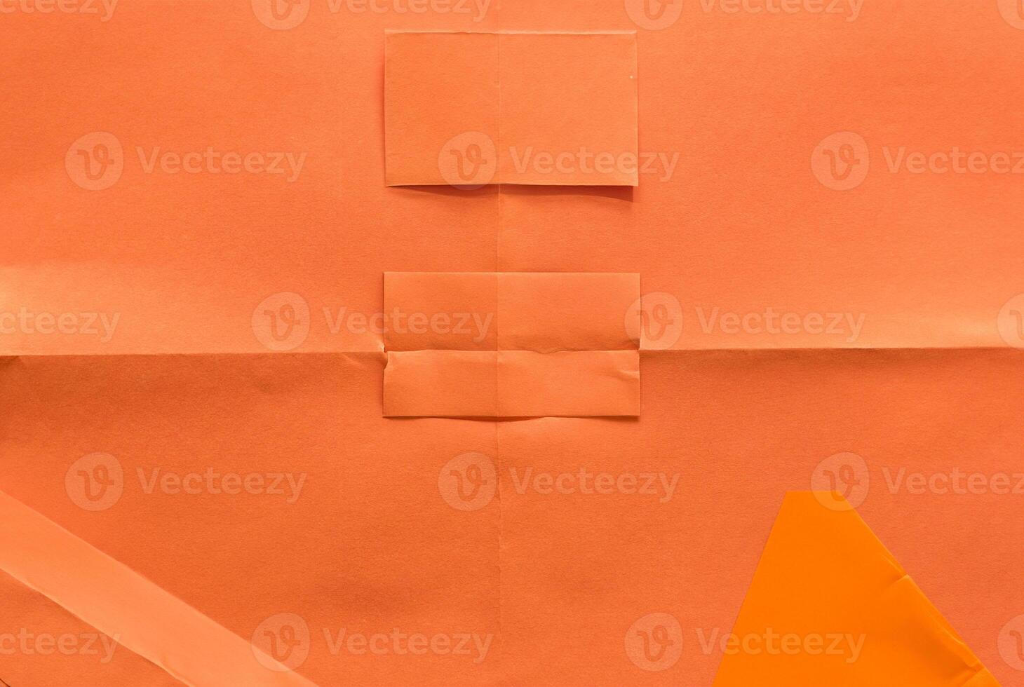 Minimal orange paper surface with visible folds and creases, ideal for backgrounds or design elements. photo