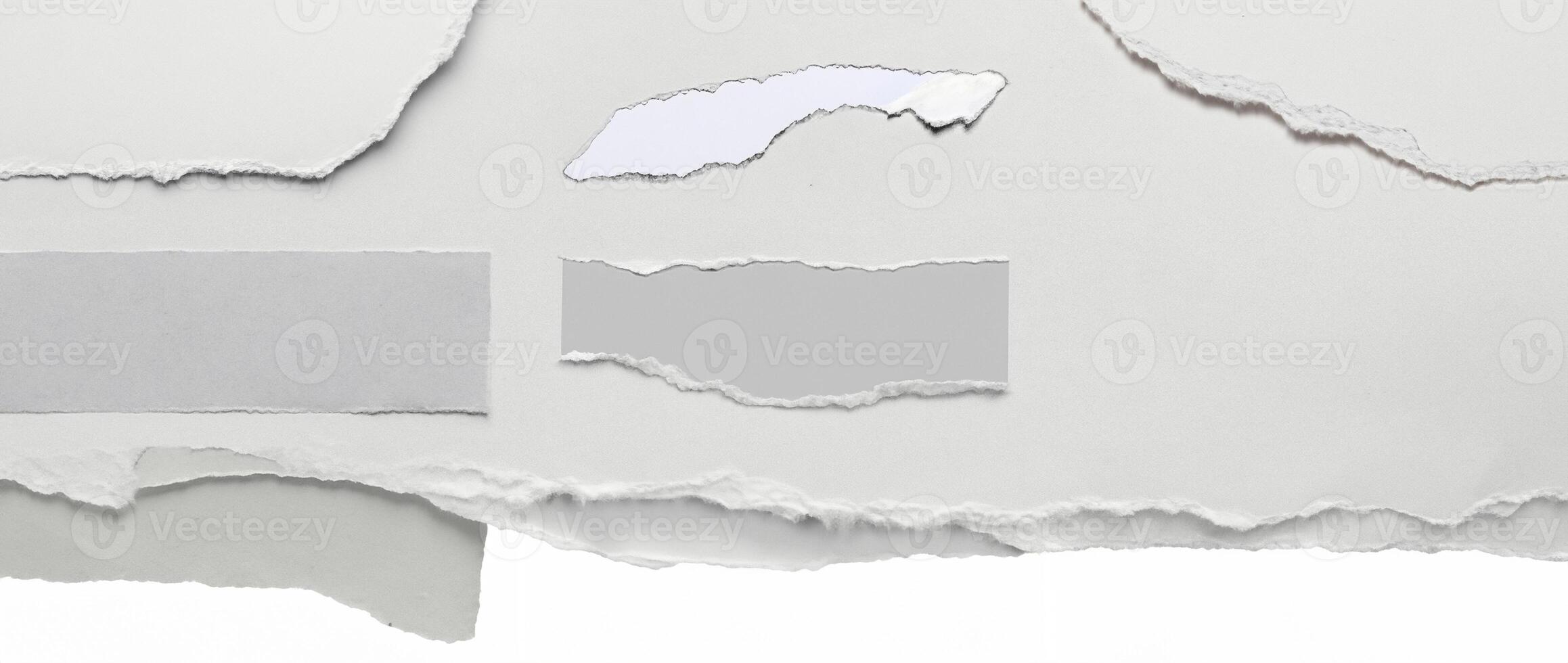 Close-up of a torn edge of white paper with rough texture, isolated on a clean white background. photo