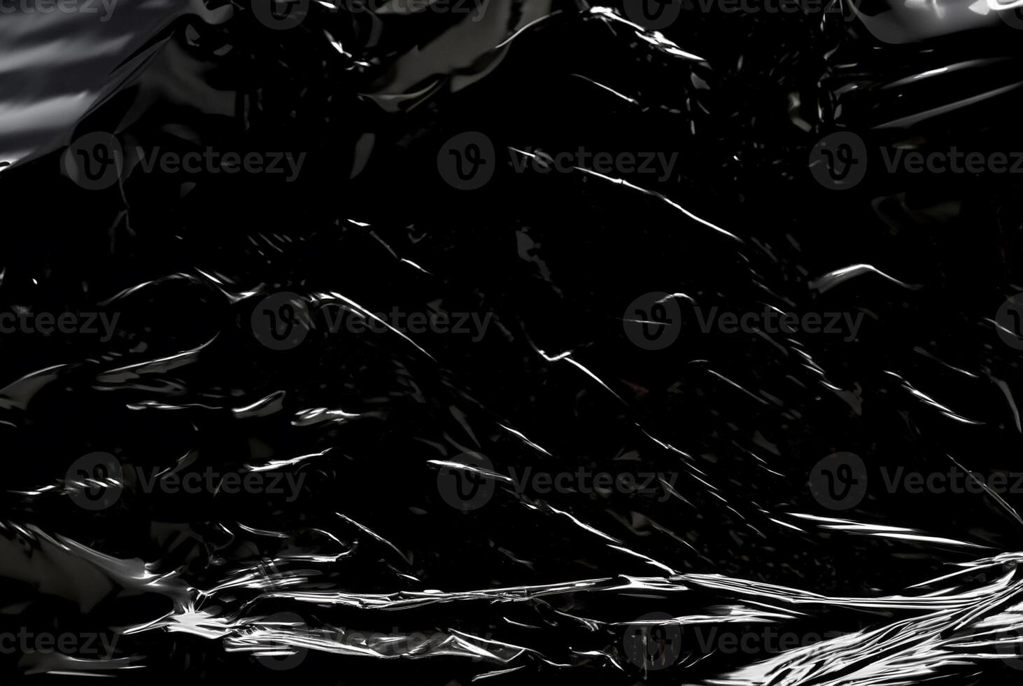 Dark abstract texture with glossy, reflective surfaces creating sharp highlights and flowing lines. photo