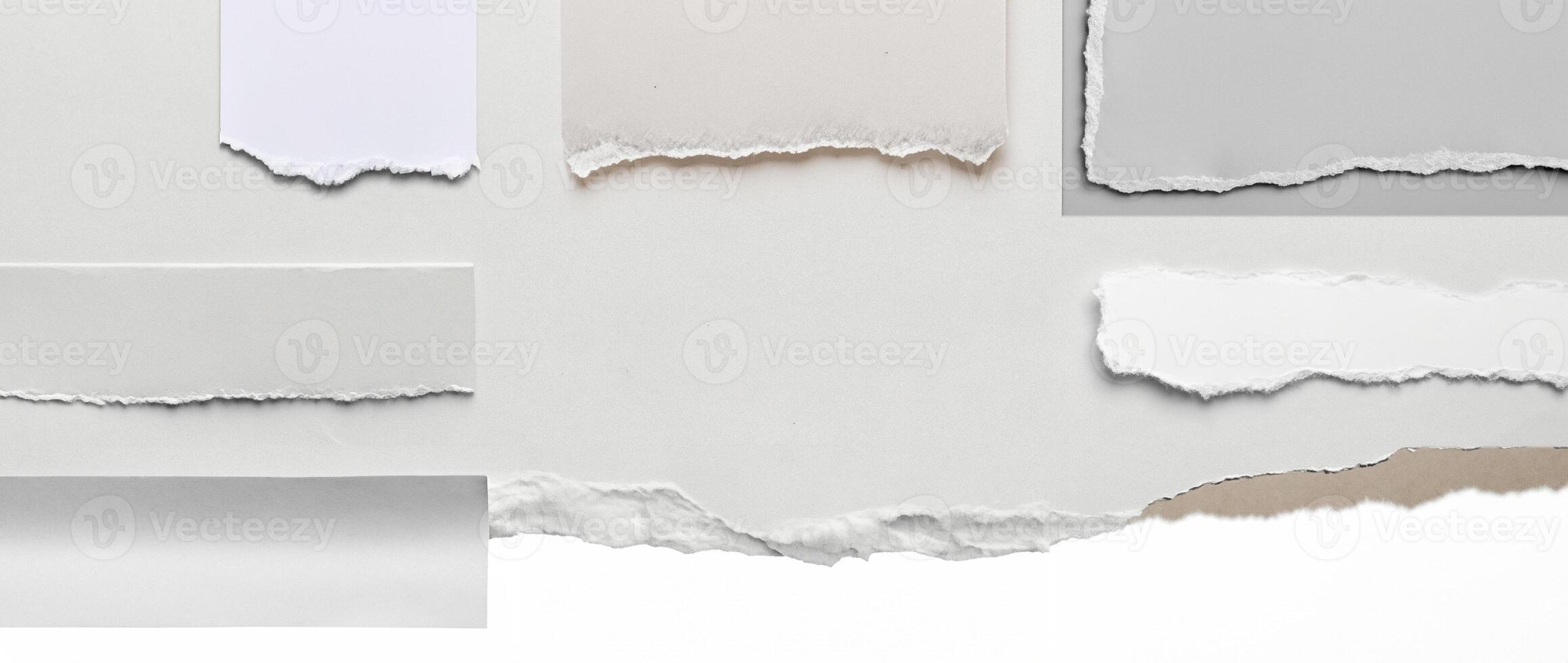 Close-up of a torn edge of white paper with rough texture, isolated on a clean white background. photo