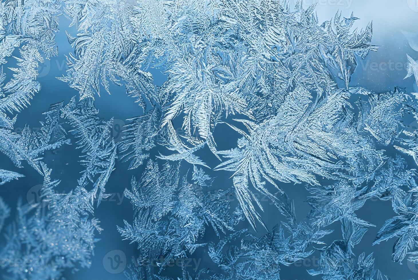 Detailed macro view of intricate frost patterns on a window surface during winter, forming natural ice crystals. photo