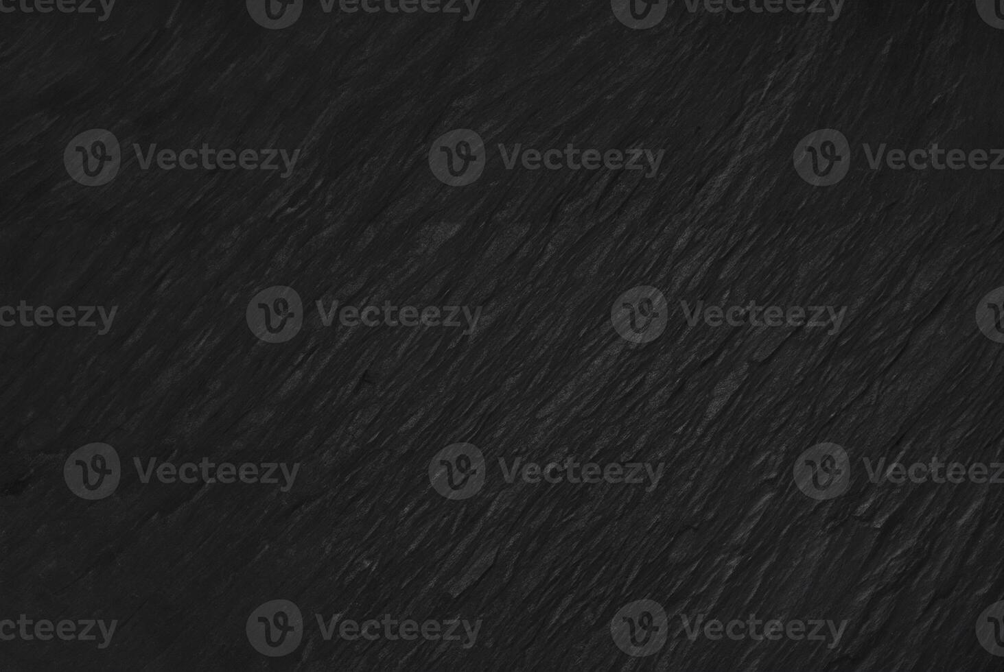 Dark textured slate surface, ideal for use as a background in design, with a subtle and natural stone texture. photo
