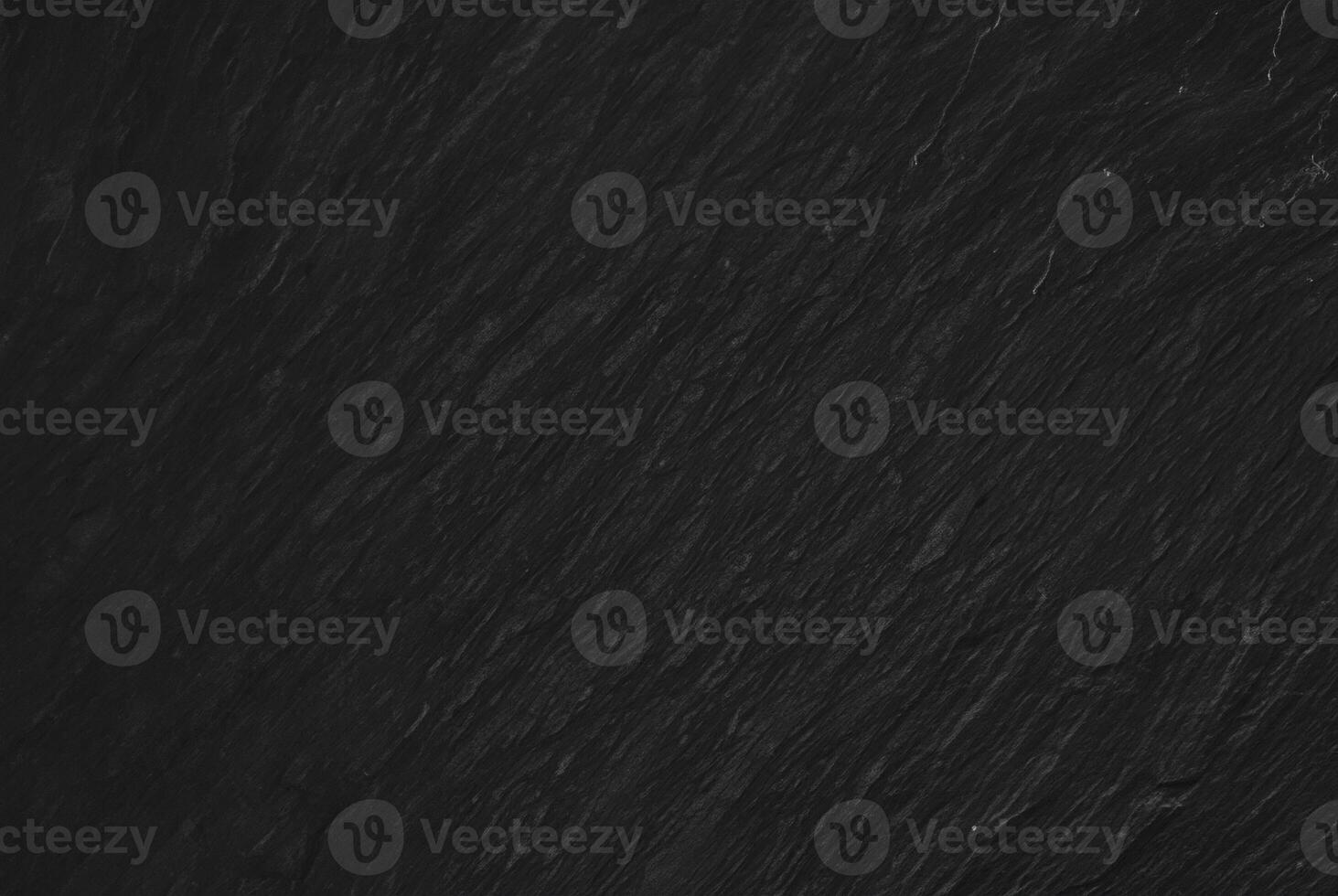 Dark textured slate surface, ideal for use as a background in design, with a subtle and natural stone texture. photo