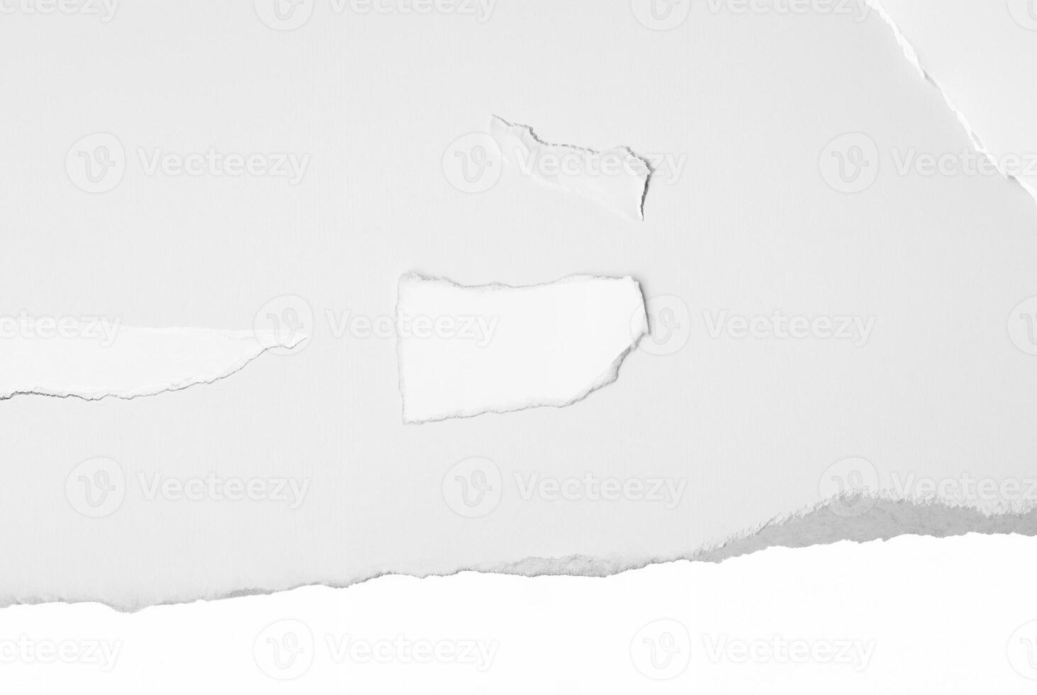 Close-up of a torn white paper edge against a clean, plain background, ideal for design or text space. photo