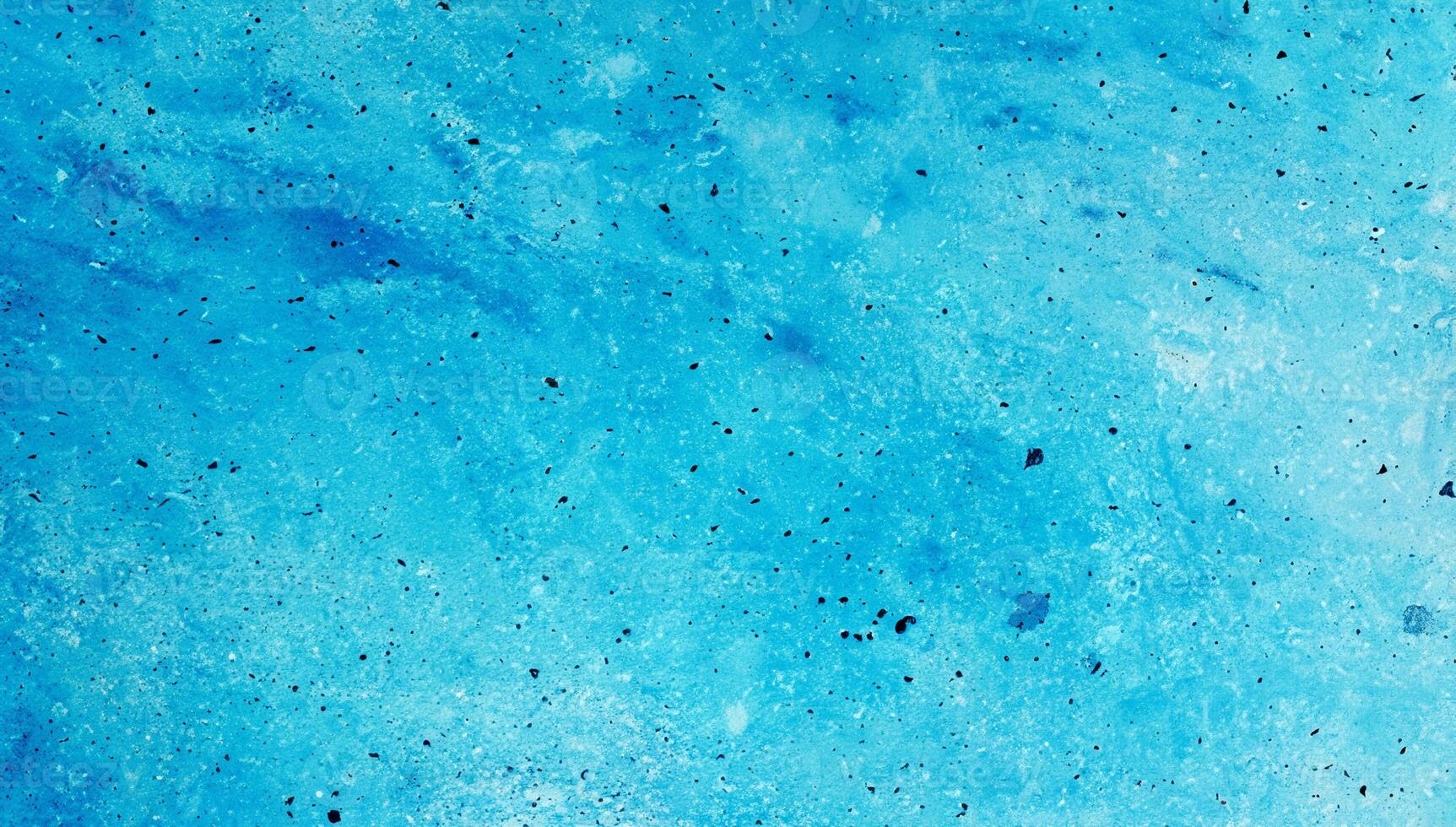 A close-up of an abstract blue textured surface with speckles and soft gradients, ideal for backgrounds or design use. photo