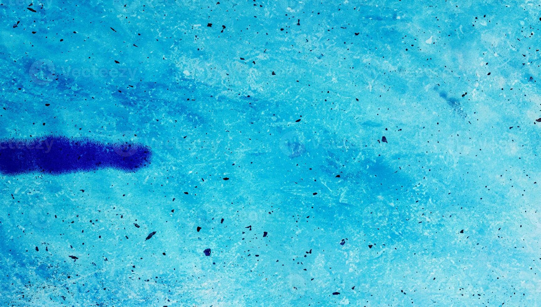 A close-up of an abstract blue textured surface with speckles and soft gradients, ideal for backgrounds or design use. photo