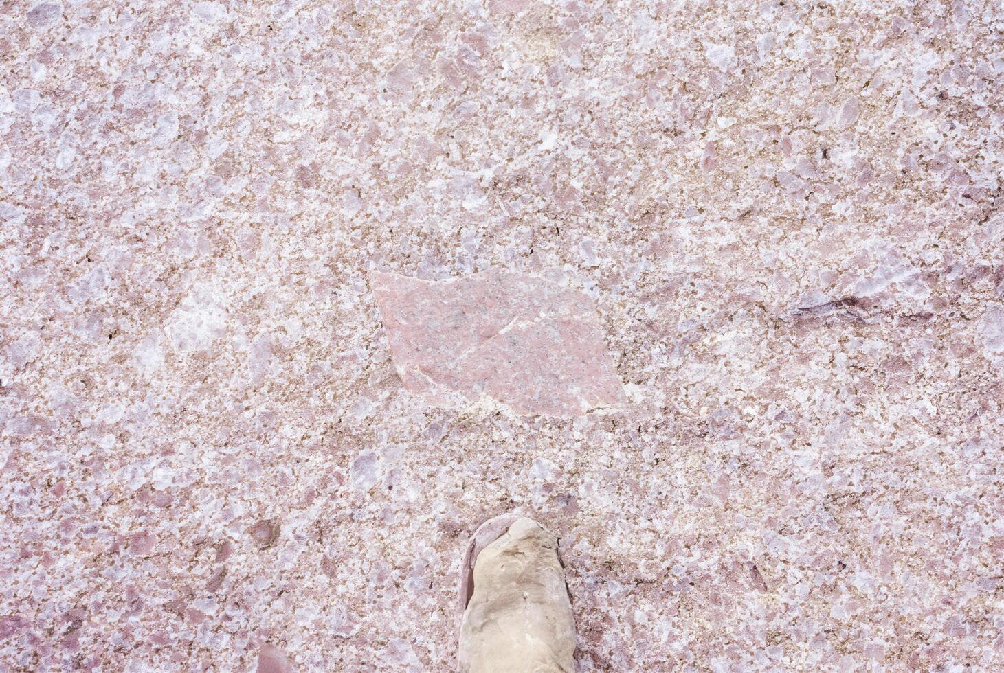 Detailed close-up texture of rough pink granite stone, perfect for background or construction design elements. photo