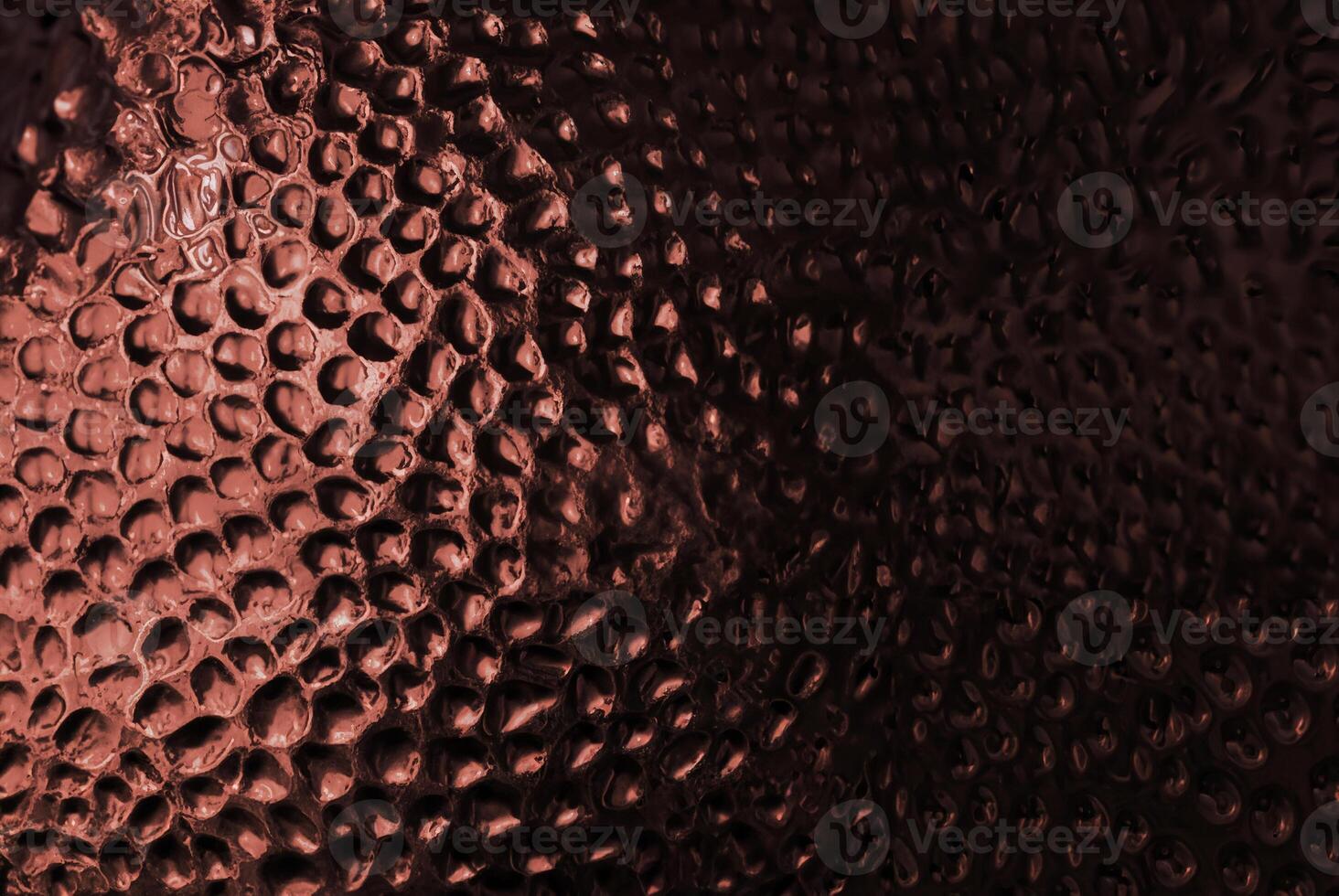 Abstract close-up of a copper-textured surface with circular patterns. photo