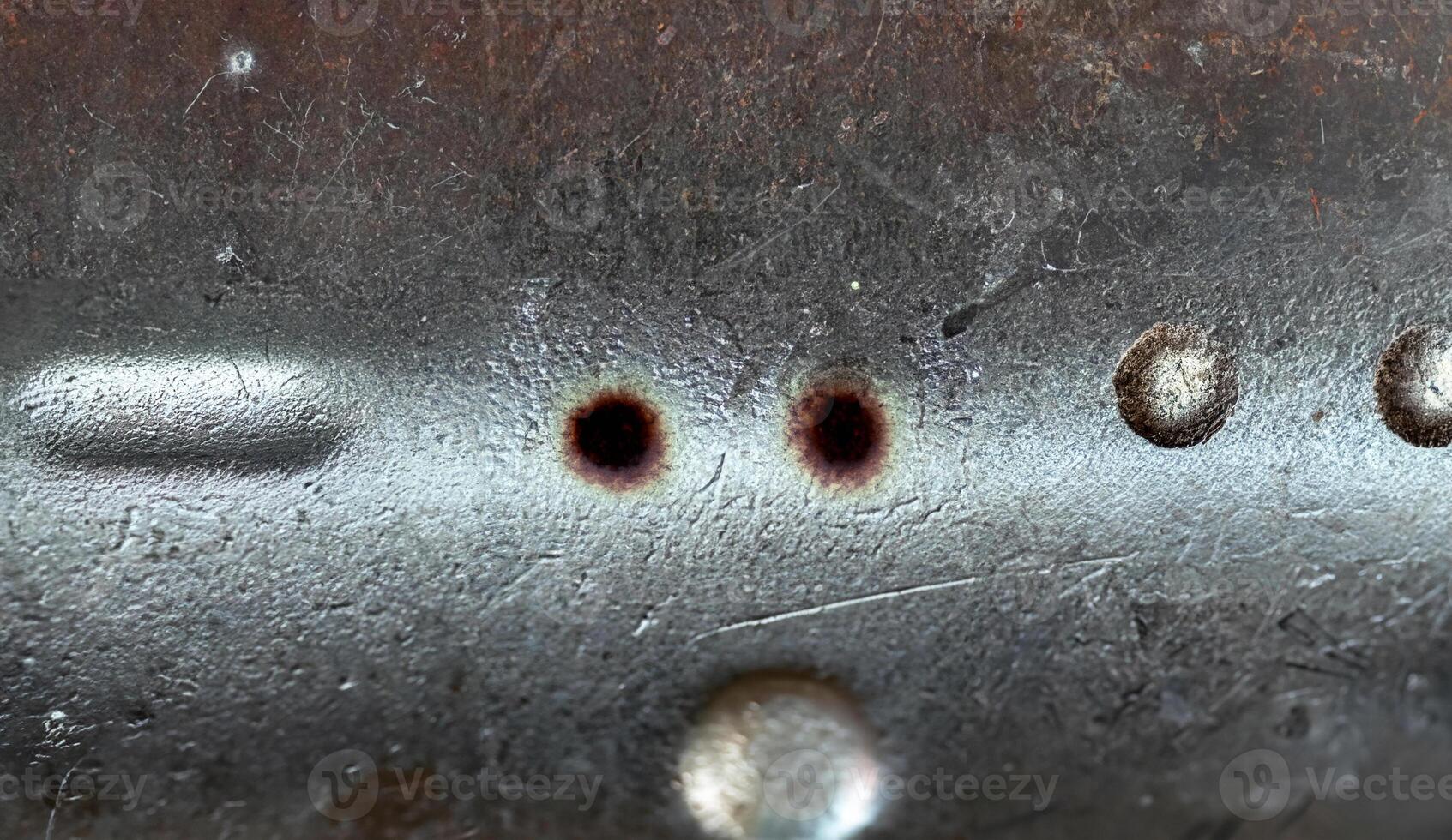 Close-up of a rough metallic surface featuring scratches, dents, and weathered texture, ideal for industrial backgrounds. photo