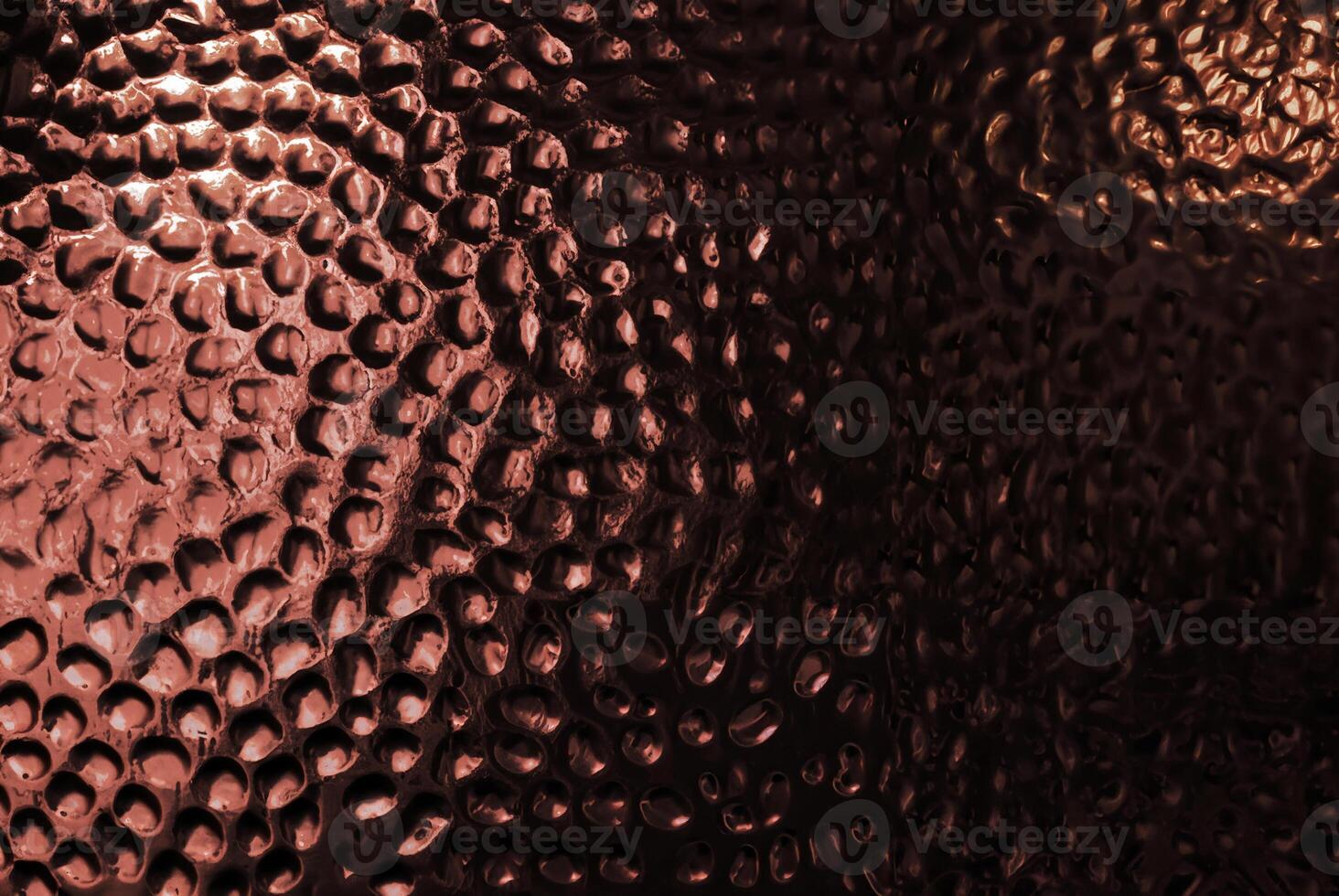 Abstract close-up of a copper-textured surface with circular patterns. photo