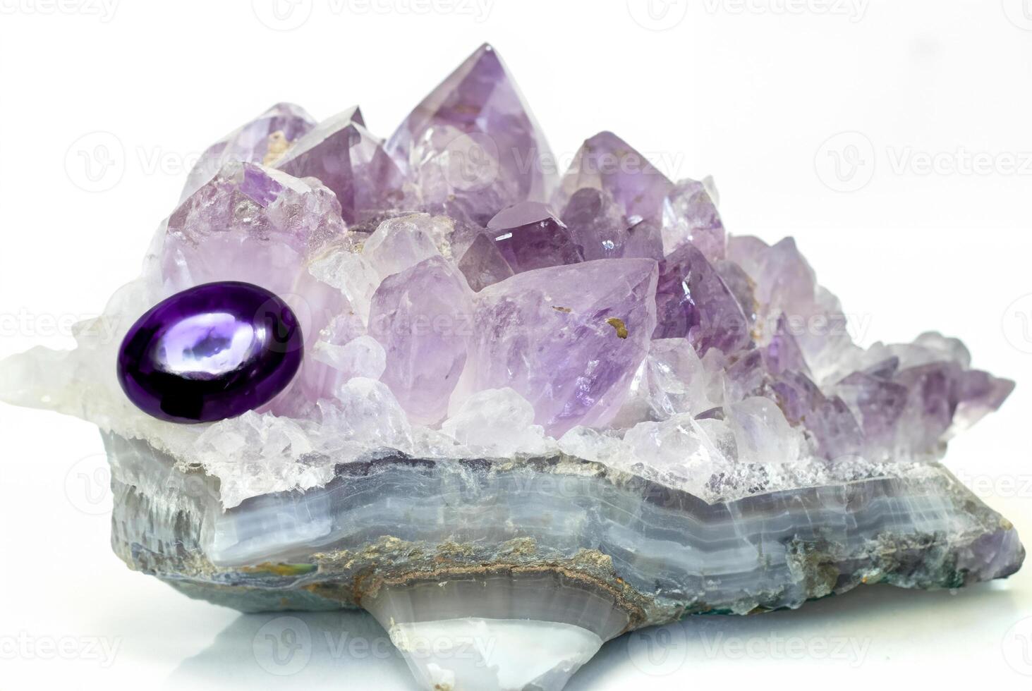 Close-up of a raw amethyst geode crystal with purple and clear quartz formations, isolated on a white background. photo
