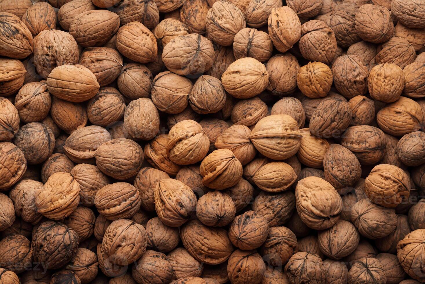 Close-up of a large pile of whole walnuts in their shells, showing a natural and organic texture. photo