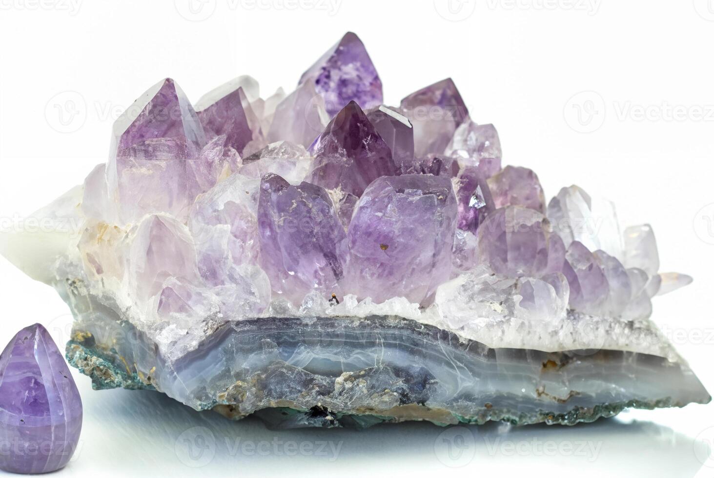 Close-up of a raw amethyst geode crystal with purple and clear quartz formations, isolated on a white background. photo