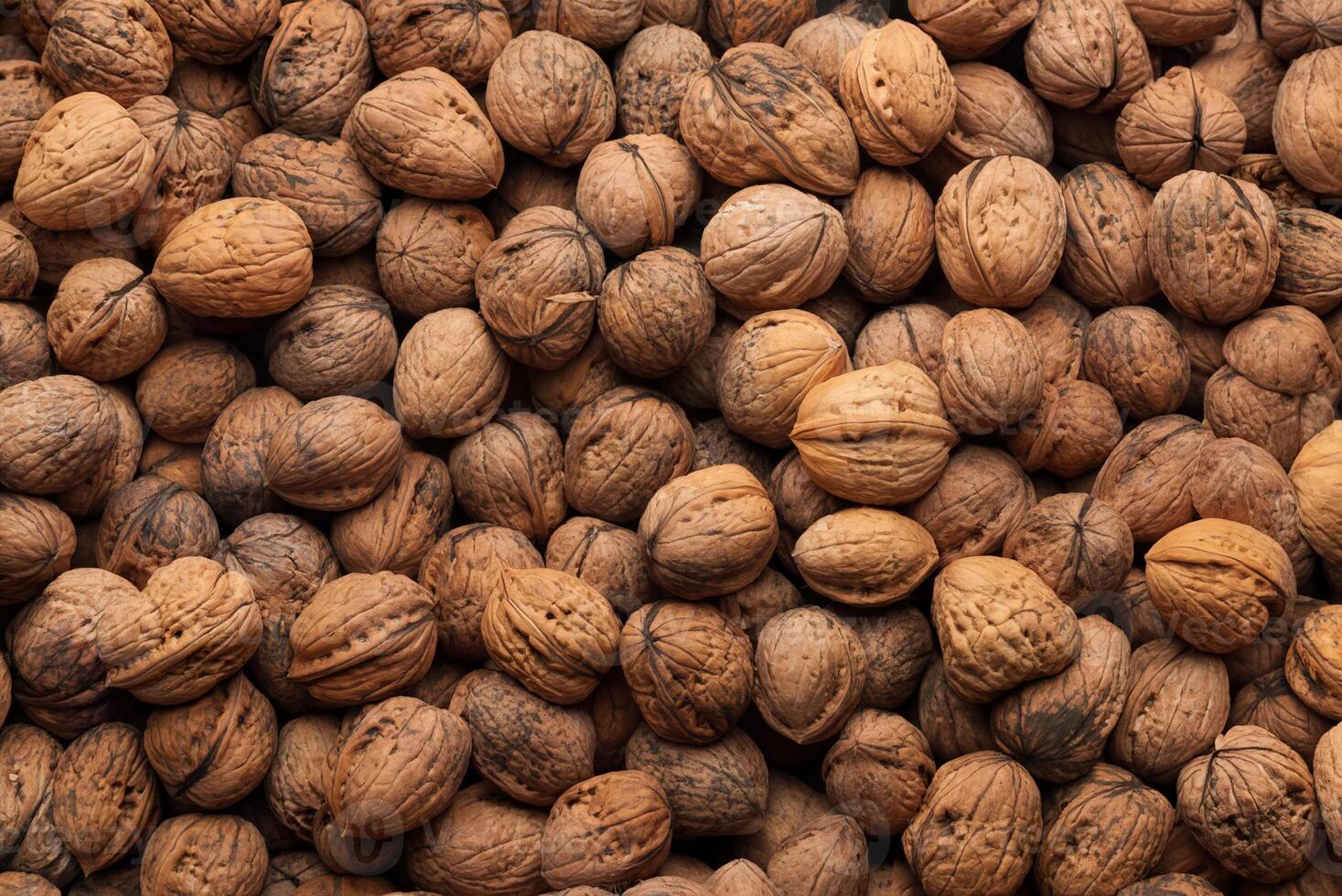 Close-up of a large pile of whole walnuts in their shells, showing a natural and organic texture. photo