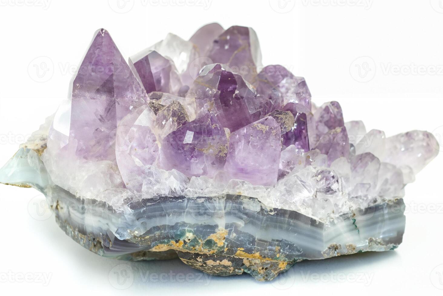 Close-up of a raw amethyst geode crystal with purple and clear quartz formations, isolated on a white background. photo