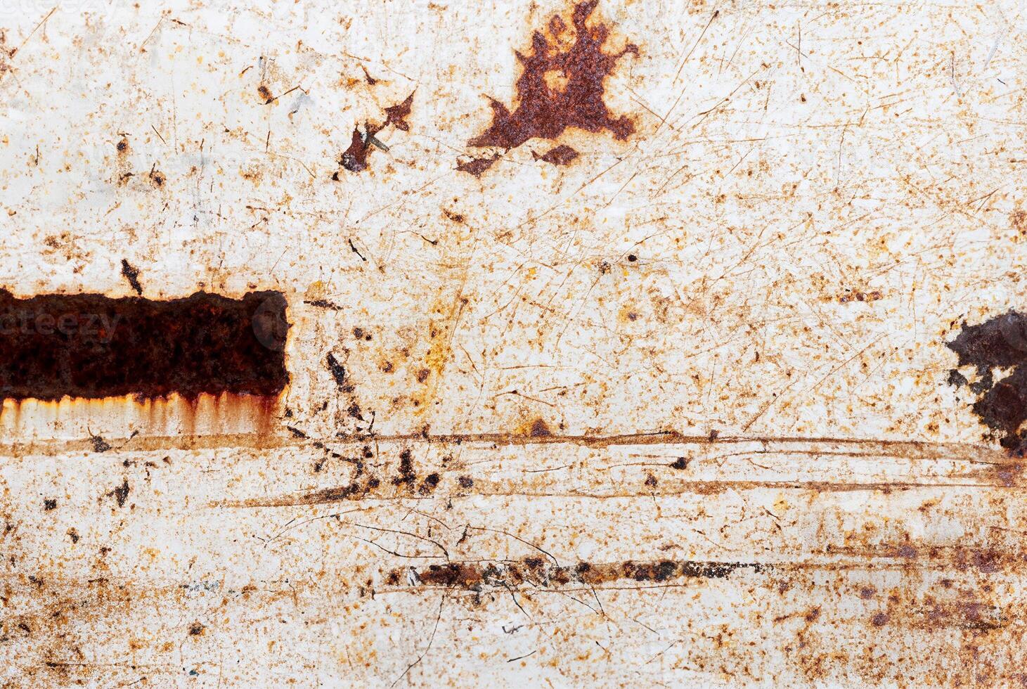 Rust-stained metal surface with scratches and weathered texture, perfect for backgrounds or industrial themes. photo