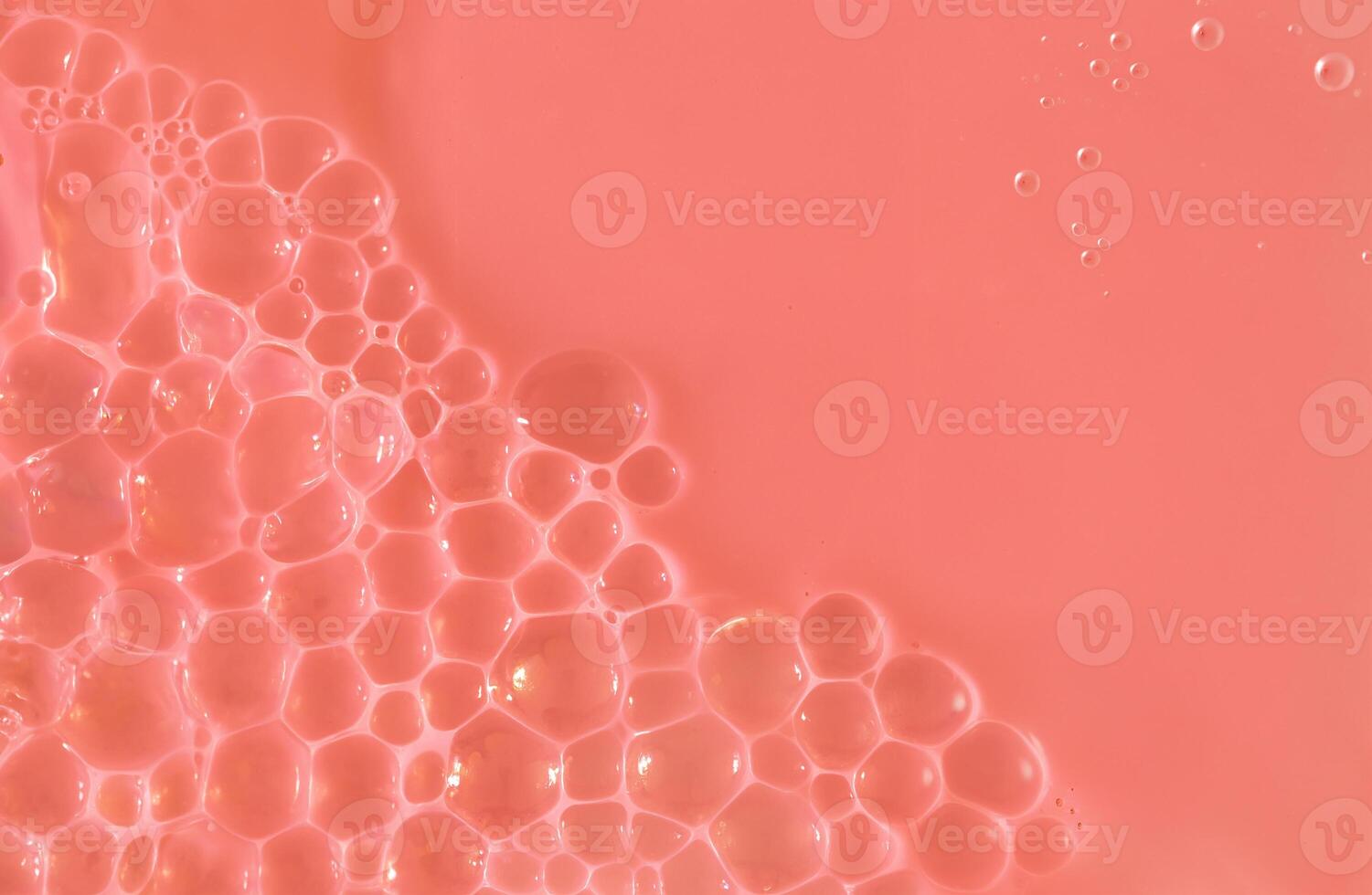 Close-up image of pink liquid with delicate bubbles forming on the surface, ideal for backgrounds, cosmetic, or science-related designs. photo